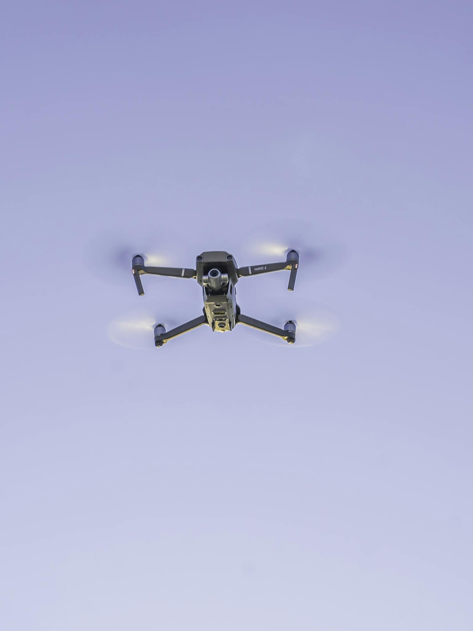 Drone flying in blue sky while recording video